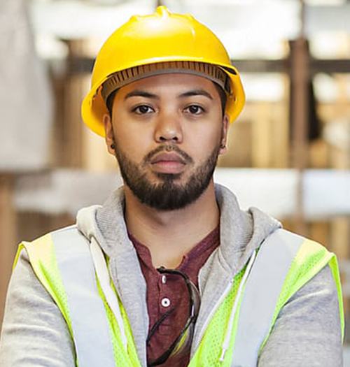 Confident construction worker wearing a yellow helmet and safety vest.