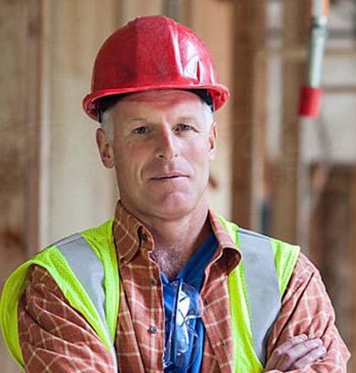 Construction worker wearing a red helmet and safety vest.