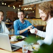 Three friends enjoying coffee and conversation at a cozy café.
