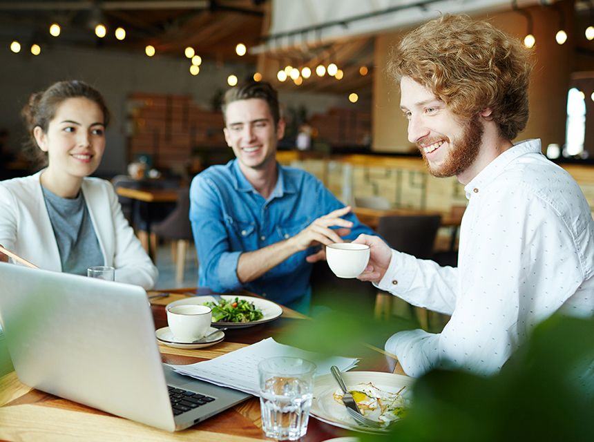 Three friends enjoying coffee and conversation at a cozy café.