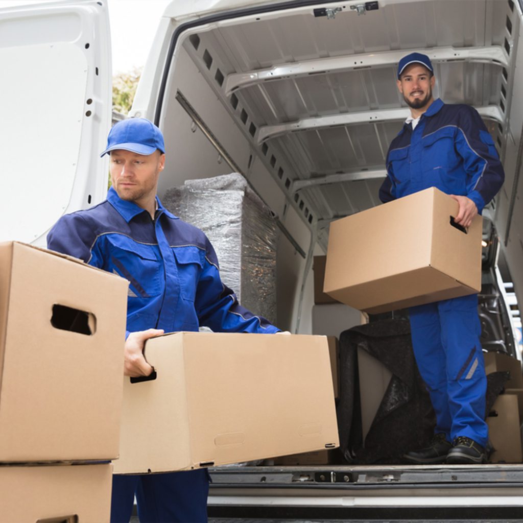 Two movers unloading boxes from a van.