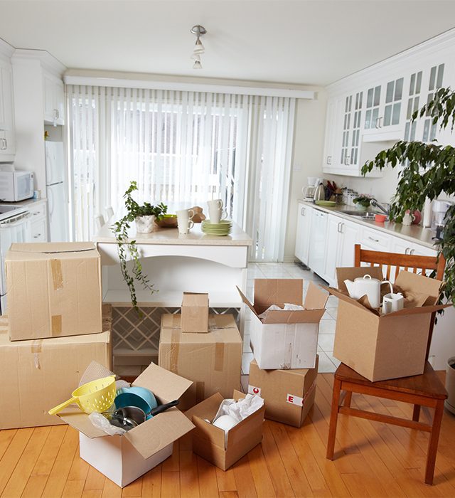 Living room filled with open moving boxes and packed items.