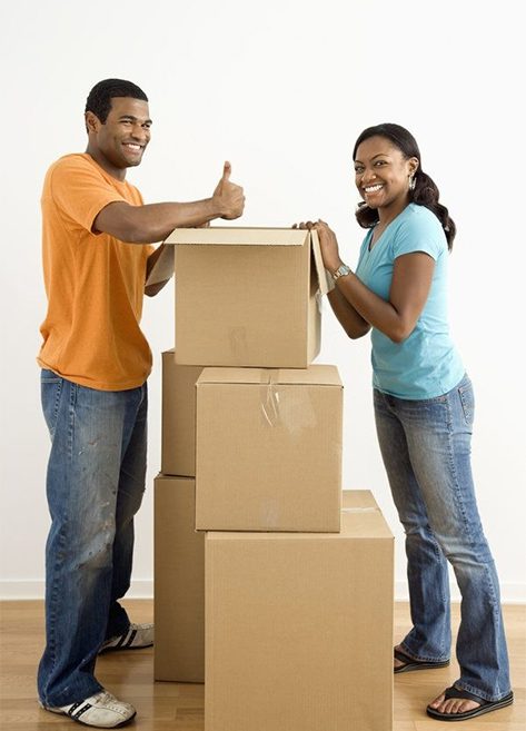 Happy couple with stacked moving boxes, ready for a new home.