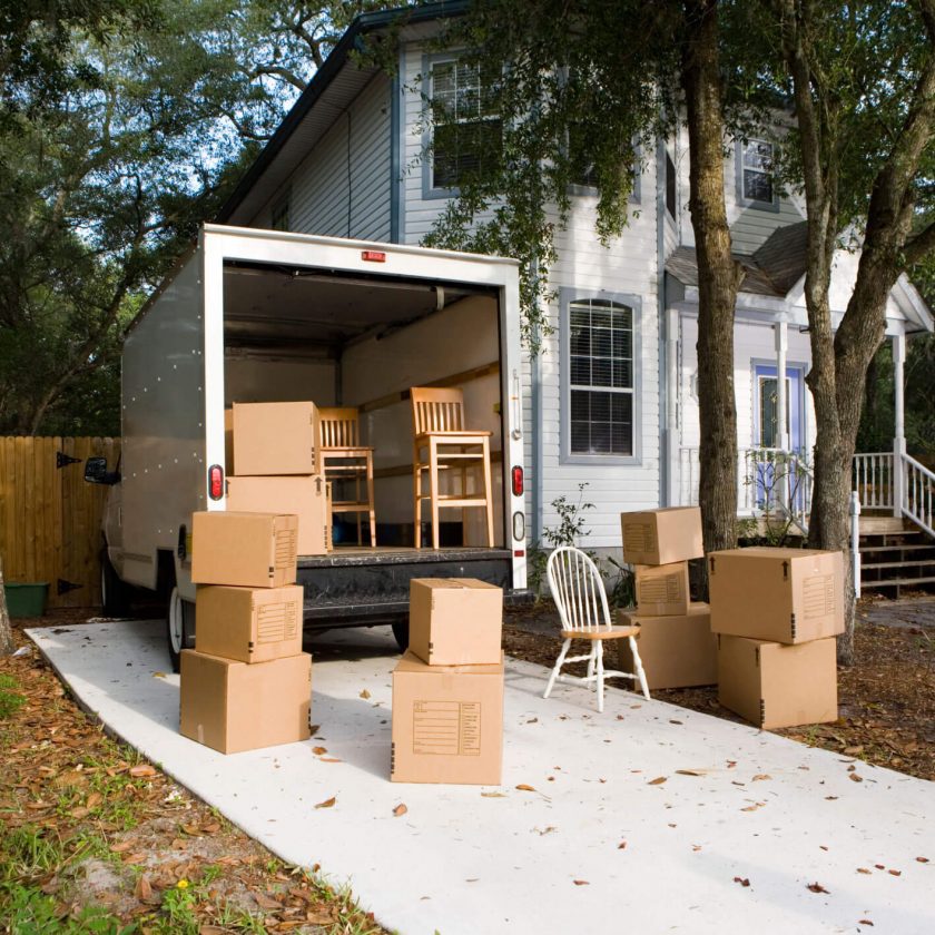 Moving boxes and furniture outside a house for relocation.