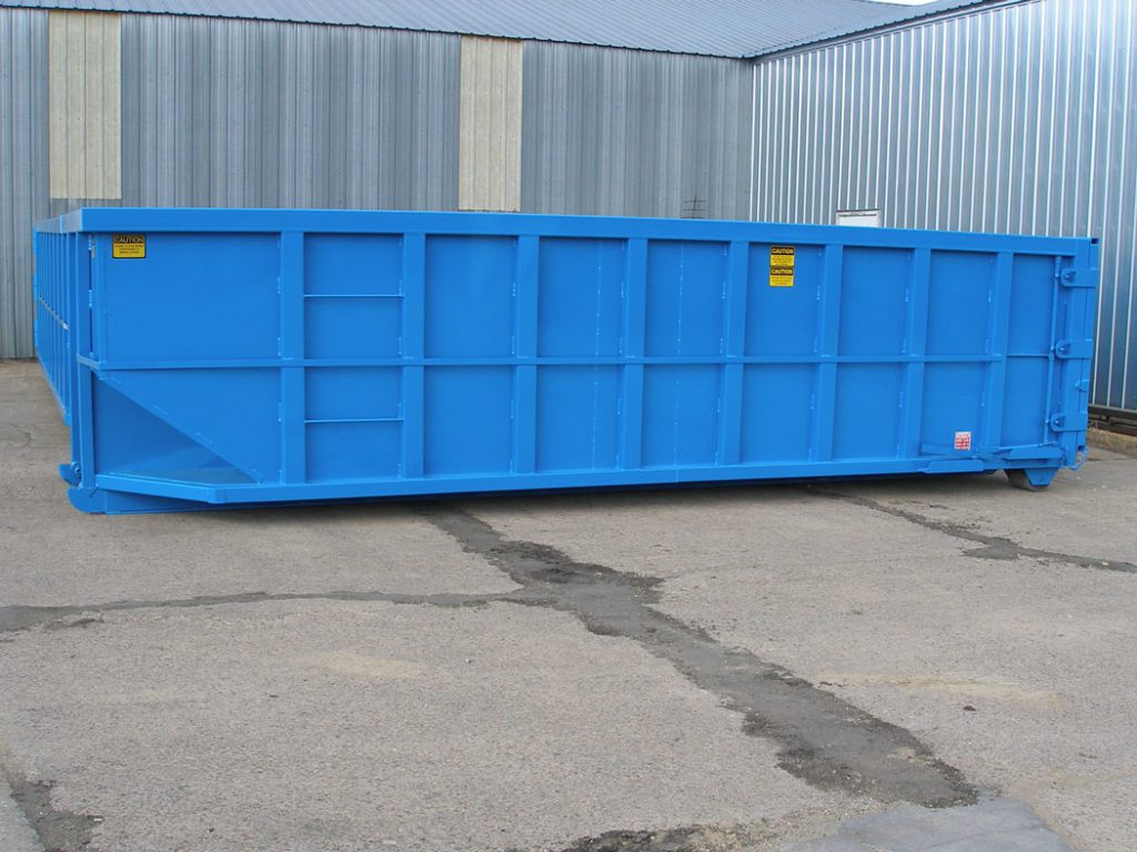 Large blue industrial dumpster outside a metal building.