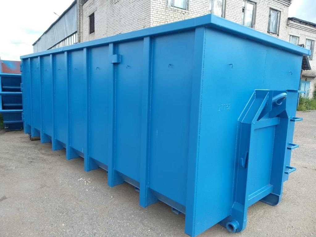 Large blue industrial dumpster outdoors near a building.